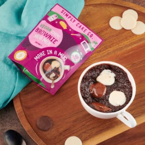 Vegan brownie mix in a mug with chocolate and marshmallow toppings, perfect for quick, delicious tre.