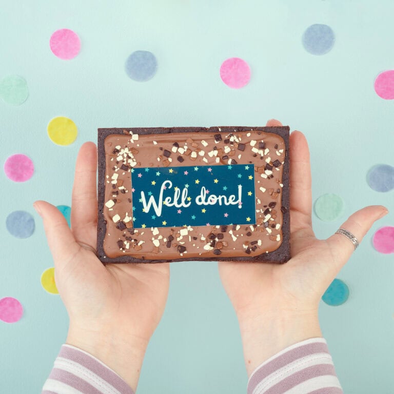 Personalised brownie slab with "Well done!" message and sprinkles, perfect for celebrations.
