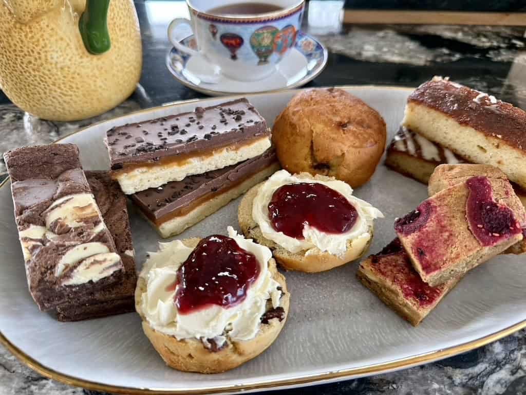 Assorted gluten-free cakes and scones for afternoon tea in a box.